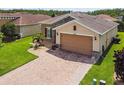 Charming home featuring a brick driveway, stone accents, and a well-manicured lawn, adding to its curb appeal at 1272 Bonita Canyon Dr, Poinciana, FL 34759