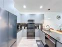 Modern kitchen features sleek gray cabinetry, stainless steel appliances, and a minimalist design at 1425 Serendipity Ln, Clermont, FL 34714