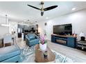 Open-concept living area with contemporary furnishings, a cozy fireplace, and an adjacent modern kitchen at 1425 Serendipity Ln, Clermont, FL 34714