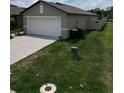 View of the side yard and driveway of a single-story home at 2034 Old Pasture Ln, Lakeland, FL 33801