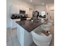 Modern kitchen features granite counters, stainless appliances, and breakfast bar seating at 2034 Old Pasture Ln, Lakeland, FL 33801