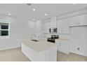 Bright kitchen with white cabinets, stainless steel appliances, quartz countertops, and an island with a sink at 227 Bull Frog Ln, Umatilla, FL 32784