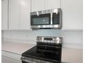 The well-equipped kitchen features stainless steel appliances and white cabinets at 232 Flag Lilly Ln, Umatilla, FL 32784
