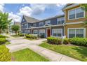 View of the townhome with colorful facades, white picket fences, and landscaped greenery at 2620 Lodi Cir # 103, Kissimmee, FL 34746
