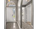 Inviting foyer with archway, showcasing wood-look flooring and neutral wall paint throughout at 265 Curtis Ave, Groveland, FL 34736