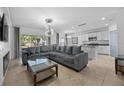 Open-concept living space with modern lighting, comfortable sectional sofa, and seamless flow to the kitchen at 2715 Barclay Ln, Kissimmee, FL 34743