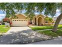 Inviting home featuring a lush green lawn, a two-car garage, and attractive landscaping at 3125 Samosa Hill Cir, Clermont, FL 34714