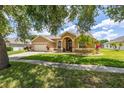 Beautiful residence with a manicured lawn, mature trees, and a welcoming entrance at 3125 Samosa Hill Cir, Clermont, FL 34714