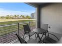 Balcony with patio seating set overlooking well-maintained lawn and landscaping at 3150 Paradox Cir # 104, Kissimmee, FL 34746