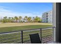 View from balcony shows a large lawn area with mature palm trees and condominium in the background at 3150 Paradox Cir # 104, Kissimmee, FL 34746