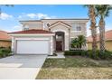 A two-story home exhibits a neutral color scheme, a red tile roof and a two-car garage at 321 Rosso Dr, Davenport, FL 33837