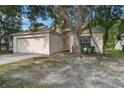 Tan single-Gathering home featuring a two-car garage, neutral paint scheme, and landscaping with mature trees at 3370 Cypress Point Cir, St Cloud, FL 34772