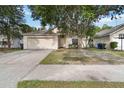 Tan single-story home with an attached garage and a well-maintained lawn area at 3370 Cypress Point Cir, St Cloud, FL 34772