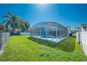 Lush green backyard featuring a screened-in pool with ample space for entertaining and relaxation at 3893 Blackberry Cir, St Cloud, FL 34769