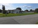 View of single story home and white picket fence with neatly manicured front lawn at 501 Kilimanjaro Dr, Kissimmee, FL 34758
