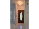 Foyer area featuring tile flooring, a decorative light fixture, and a dark wood front door at 501 Kilimanjaro Dr, Kissimmee, FL 34758