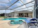 Screened-in pool and spa offer a private oasis with lounge seating and covered patio, perfect for entertaining at 518 Brighton Dr, Davenport, FL 33897