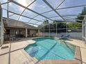 Inviting screened-in pool and spa area with ample seating and a covered patio, creating a serene outdoor space at 518 Brighton Dr, Davenport, FL 33897
