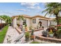 Home featuring beautiful landscaping with a variety of plants, flowers, and brick-lined garden beds at 608 Grand Canal Dr, Poinciana, FL 34759