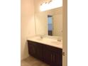 Bathroom with dual sinks, dark cabinetry, and large mirror at 8607 Crescendo Ave, Windermere, FL 34786