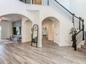 Elegant foyer with arched doorways, a staircase with wrought iron railings, and wood-look tile flooring at 1211 Terralago Way, Kissimmee, FL 34746
