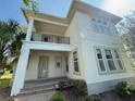Charming two-story home featuring a balcony, a manicured lawn and lush landscaping at 13065 Gabor Ave, Orlando, FL 32827