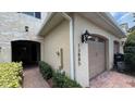 Townhouse showing brick-paved walkway, an attached garage, and a decorative outdoor light fixture at 13885 Arclid St, Orlando, FL 32832