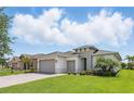 Attractive home with a well-manicured lawn, brick driveway, and a spacious three-car garage at 142 Olympus Way, Kissimmee, FL 34759