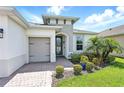 Inviting home entrance, showcasing the front door, lush greenery, and a neat brick walkway at 142 Olympus Way, Kissimmee, FL 34759