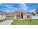 Charming single-story home with a well-manicured lawn and attached two-car garage at 143 Brixham Ct, Kissimmee, FL 34758