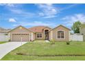 Well-maintained single-Gathering home featuring a lush green lawn and attached two-car garage at 143 Brixham Ct, Kissimmee, FL 34758