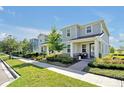 Well-maintained two-story home with lush landscaping along the sidewalk at 14389 Lanikai Beach Dr, Orlando, FL 32827