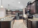 Modern kitchen featuring stainless steel appliances, granite countertops, and dark wood cabinetry at 1470 Lake Side Ave, Davenport, FL 33837