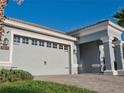 Garage detail showcasing the large garage door with decorative windows and black hardware, framed by mature landscaping at 1508 Bunker Drive Bunker, Davenport, FL 33896