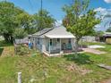 Aerial view of a cozy home with a covered porch and carport surrounded by greenery at 1626 Gar St, St Cloud, FL 34771