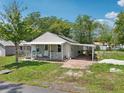 Charming house with a covered front porch, side carport, and lush greenery at 1626 Gar St, St Cloud, FL 34771