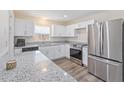 Modern kitchen with stainless steel appliances, granite countertops, and bright white cabinetry at 1712 Melvin Ave, Orlando, FL 32806