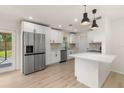 Modern kitchen with stainless steel appliances, white cabinets, and a stylish backsplash at 1842 Puritan Ave, Winter Park, FL 32792