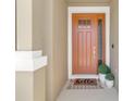 Inviting front door with a 'hello' mat and potted plants, creating a warm welcome at 2679 Ridgetop Ln, Clermont, FL 34711