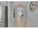 Hallway featuring modern lighting, light wood floors, and neutral paint, leading to the front door at 2679 Ridgetop Ln, Clermont, FL 34711