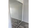 Bedroom with mirrored closet doors and neutral gray vinyl plank flooring at 2826 Club Cortile Cir # B, Kissimmee, FL 34746