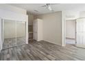 Bright bedroom featuring hardwood floors, ceiling fan, mirrored closet, and white trim at 2826 Club Cortile Cir # B, Kissimmee, FL 34746