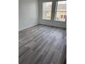 A light filled bedroom with gray vinyl plank flooring and large windows at 2826 Club Cortile Cir # B, Kissimmee, FL 34746