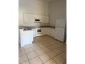 A well lit kitchen with white cabinets, tile floors, and new appliances at 2826 Club Cortile Cir # B, Kissimmee, FL 34746