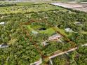 Expansive property outlined in red, featuring a pond and surrounded by a dense canopy of trees for seclusion at 2851 Wagon Ct, St Cloud, FL 34772