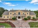 Stunning two-story tan home featuring a brick drive, covered front porch and a 2nd story veranda at 2851 Wagon Ct, St Cloud, FL 34772