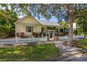 Charming yellow home with a white picket fence and lush landscaping at 3349 Schoolhouse Rd, Harmony, FL 34773
