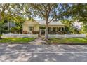 Charming yellow home with a white picket fence and lush landscaping at 3349 Schoolhouse Rd, Harmony, FL 34773