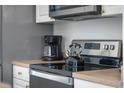 Close-up on updated kitchen appliances and countertops featuring a coffee maker and electric kettle at 344 High Point Dr, Davenport, FL 33837