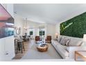 Bright living room with modern decor, plush seating, and views of the outdoor pool area at 344 High Point Dr, Davenport, FL 33837